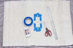 Step 2 utilizing painter's tape to create a kilim-style design for a painted rug