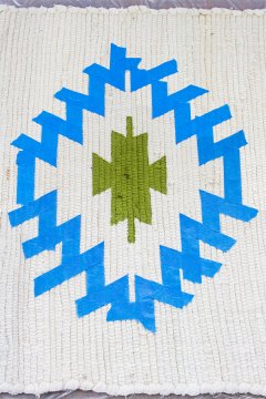 Using artist's tape to mark a kilim-style design onto a little cotton fiber rug